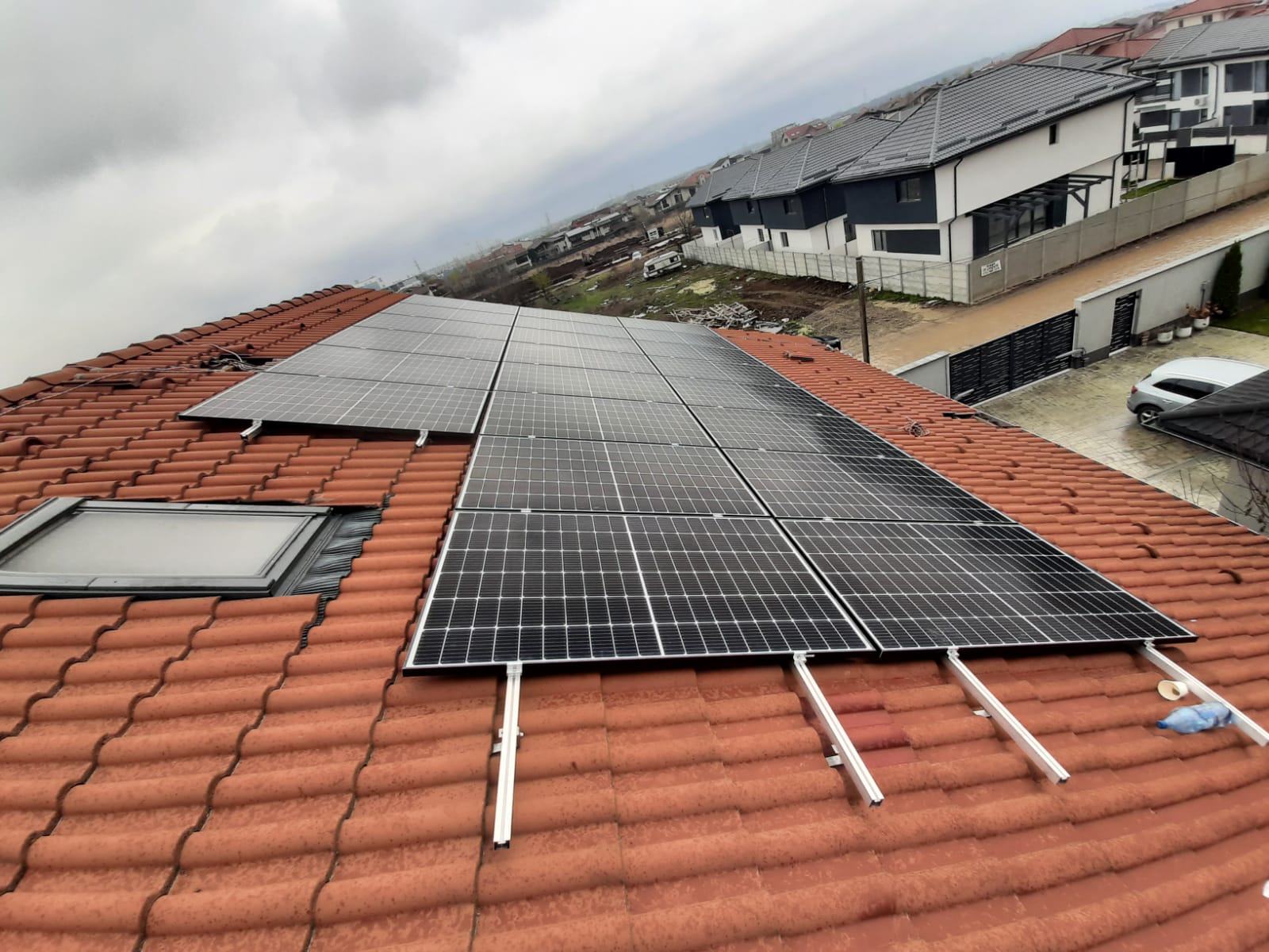 Panouri fotovoltaice pe acoperiș din țiglă roșie, cartier rezidențial