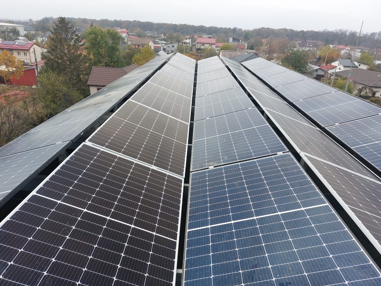 Șiruri de panouri fotovoltaice pe hală industrială